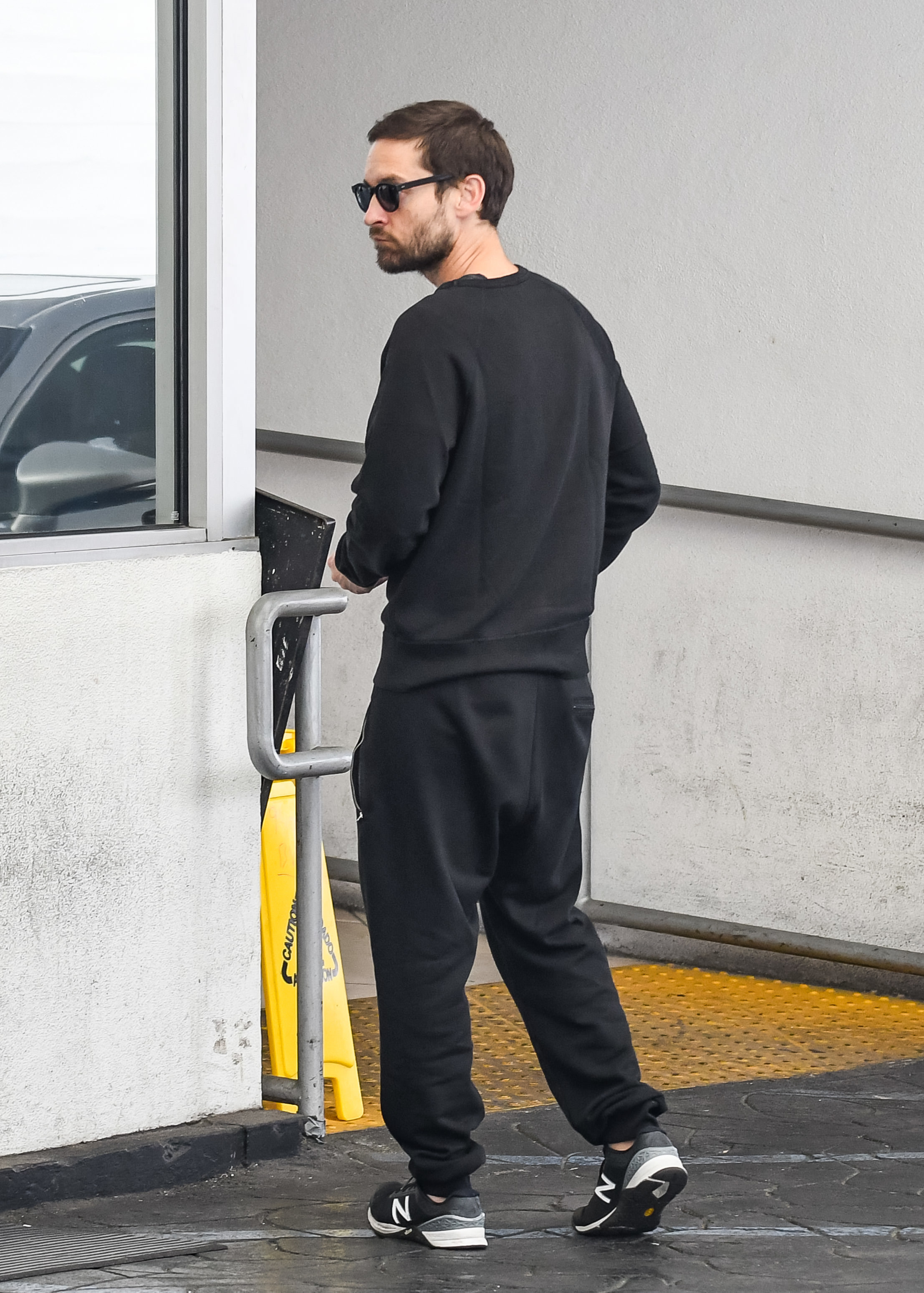 Tobey in sunglasses, a sweatsuit, and sneakers
