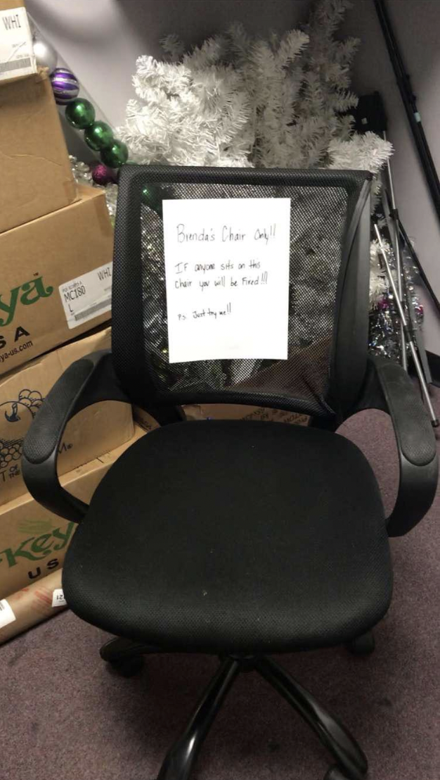 A picture of the chair in question with a sign on it that says &quot;Brenda&#x27;s chair only, if anyone sits on this, you&#x27;ll be fired, P.S. just try me&quot;