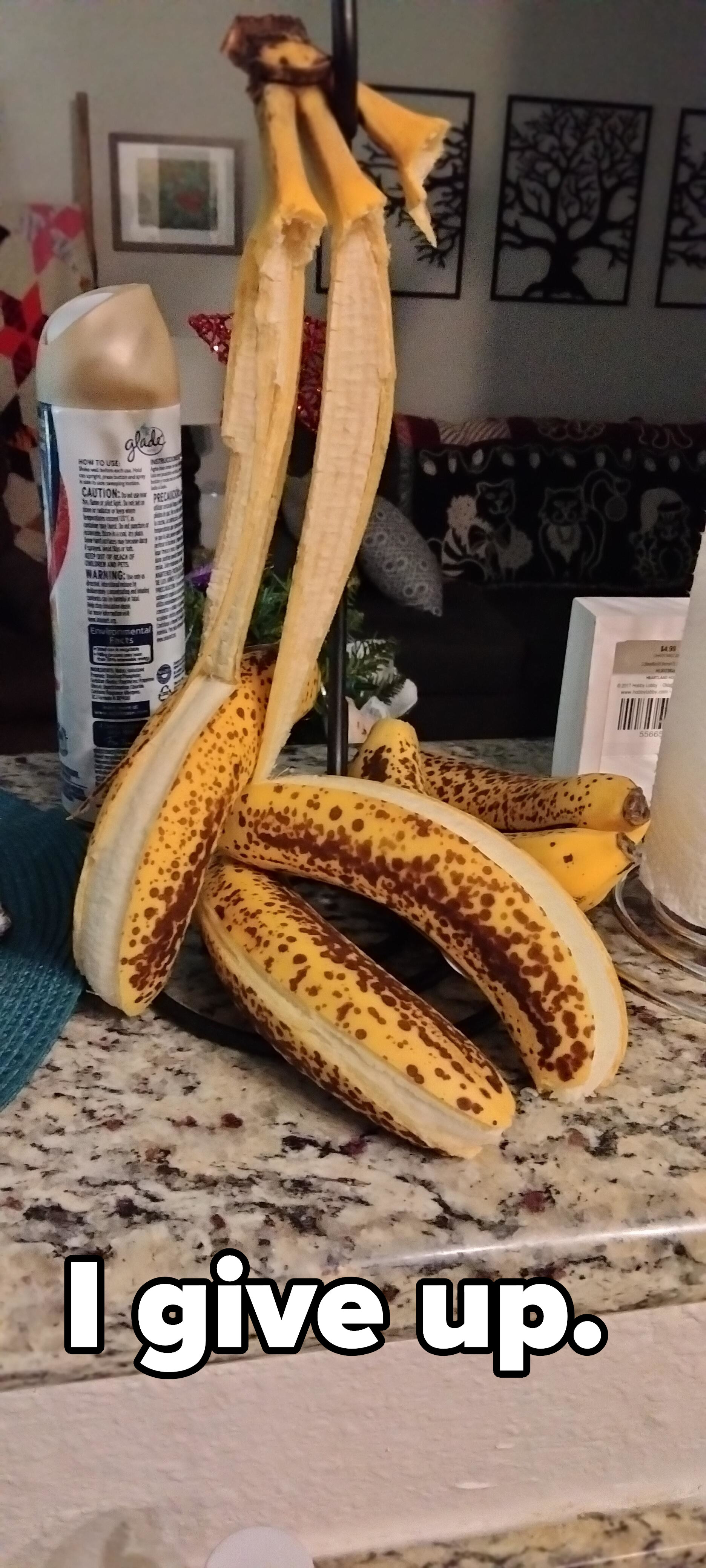 bananas hanging from a fruit stand that have peeled by themselves