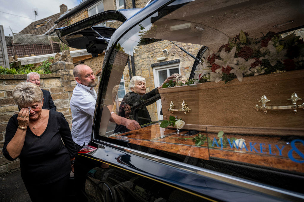 People crying while paying respects to their loved one in casket