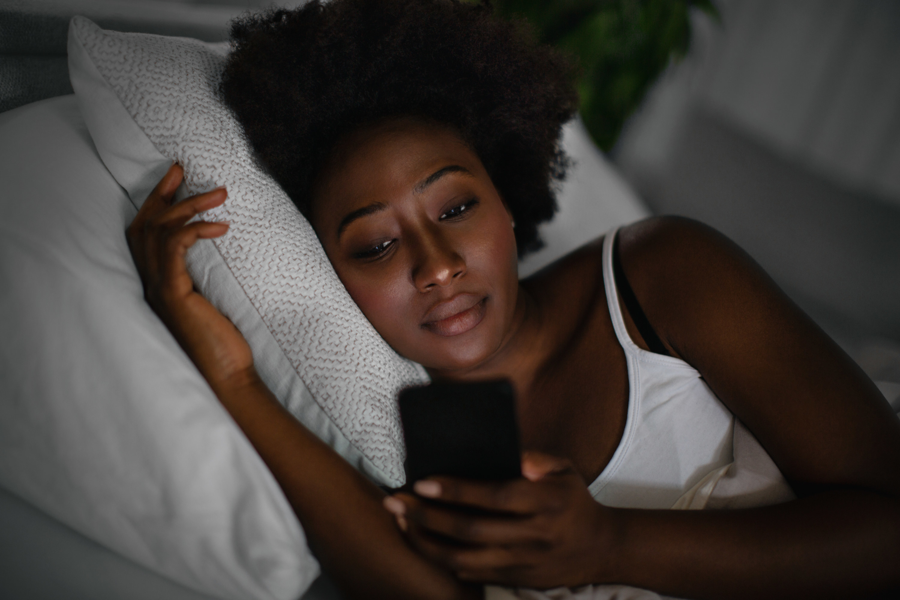 A woman on her phone in bed