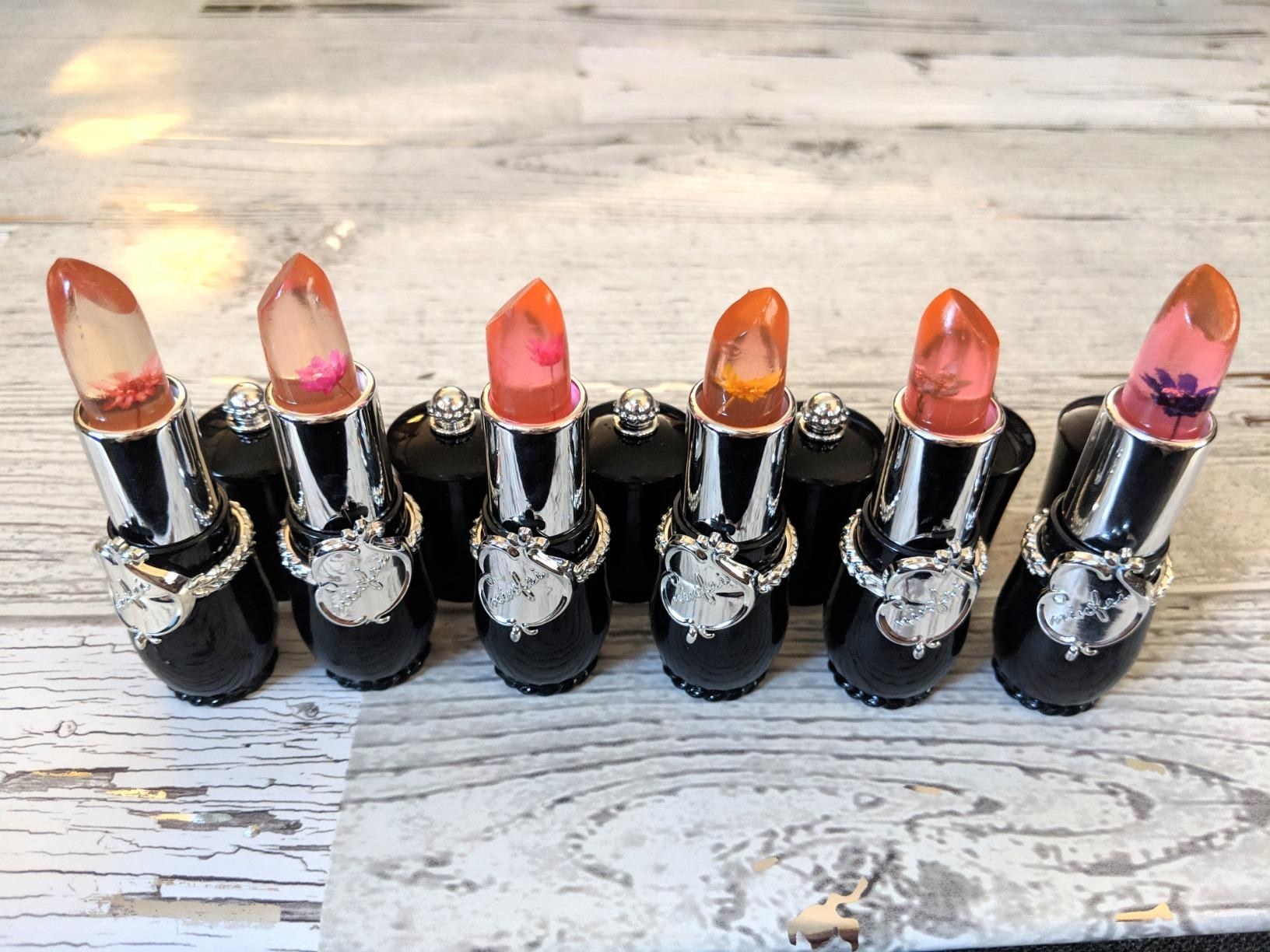 a set of six black lip tints with flowers inside