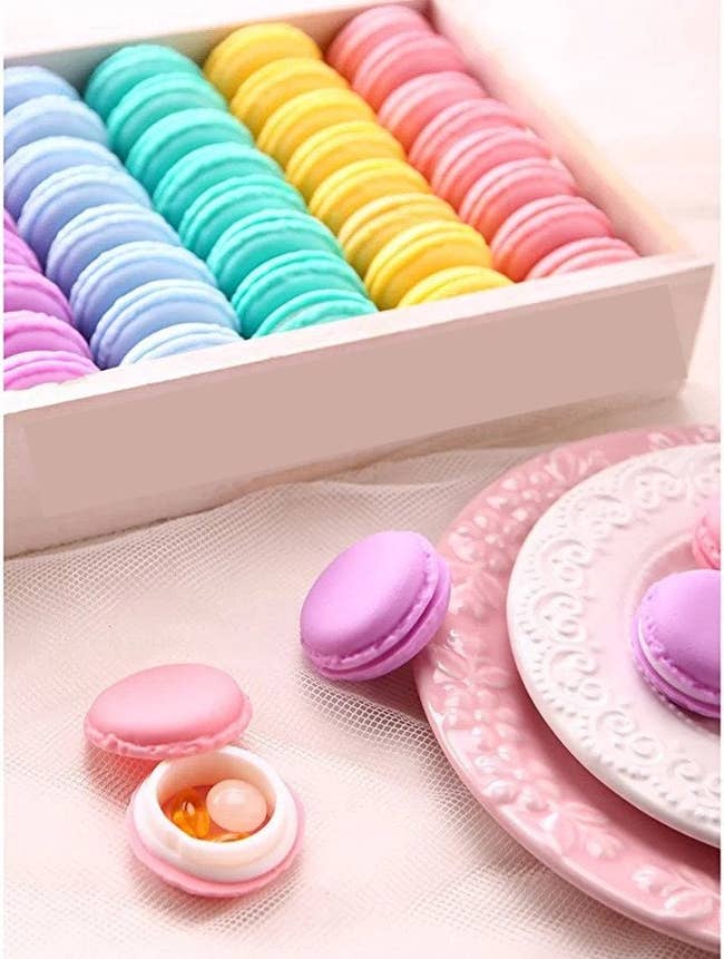 a macaron-shaped pill box beside a colorful assortment of macarons
