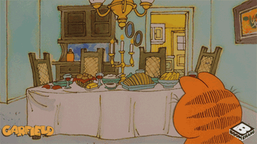 Garfield in front of dinner table full of food