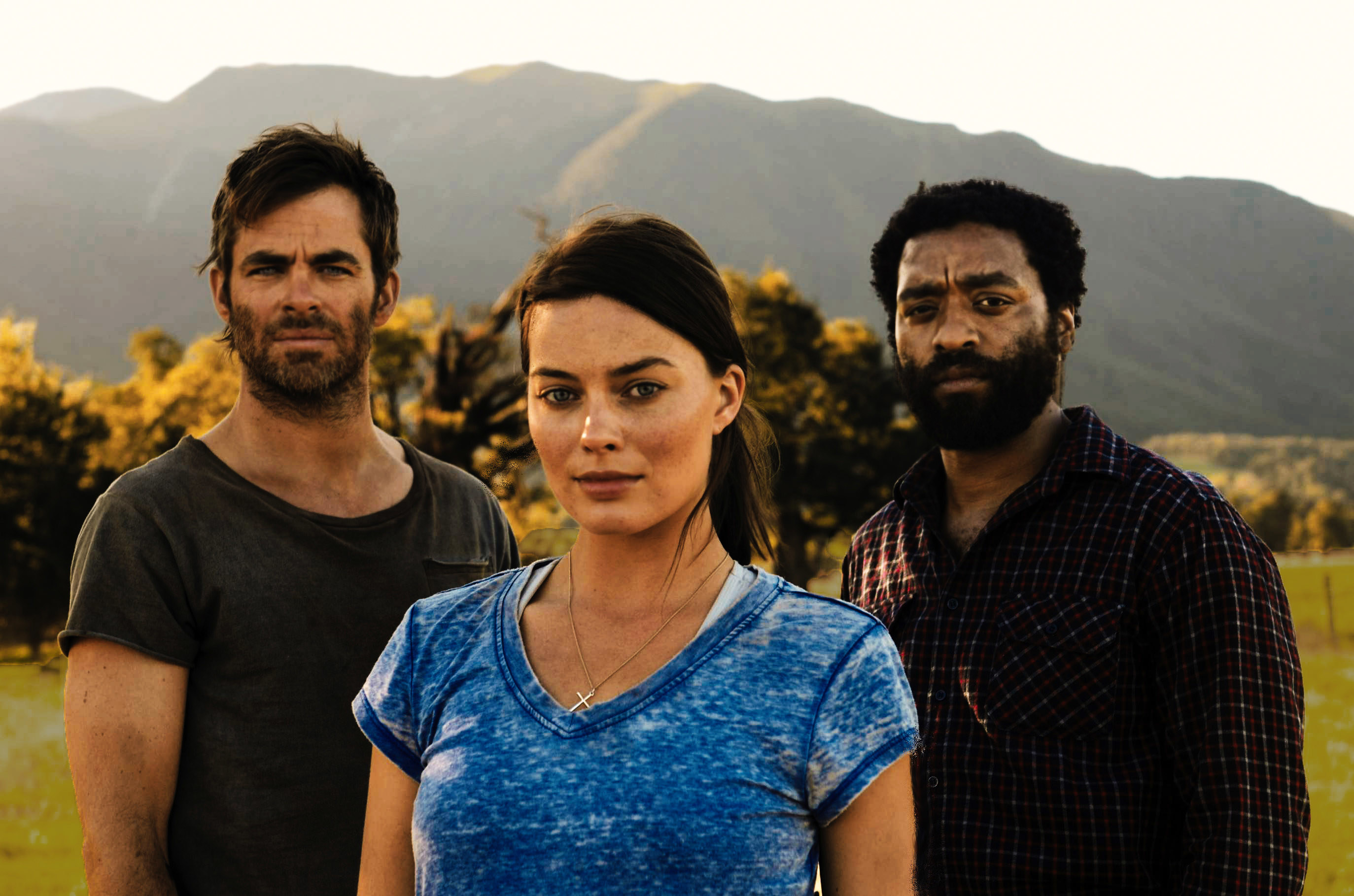 Chris Pine, Margot Robbie, and Chiwetel Ejiofor stand in a field