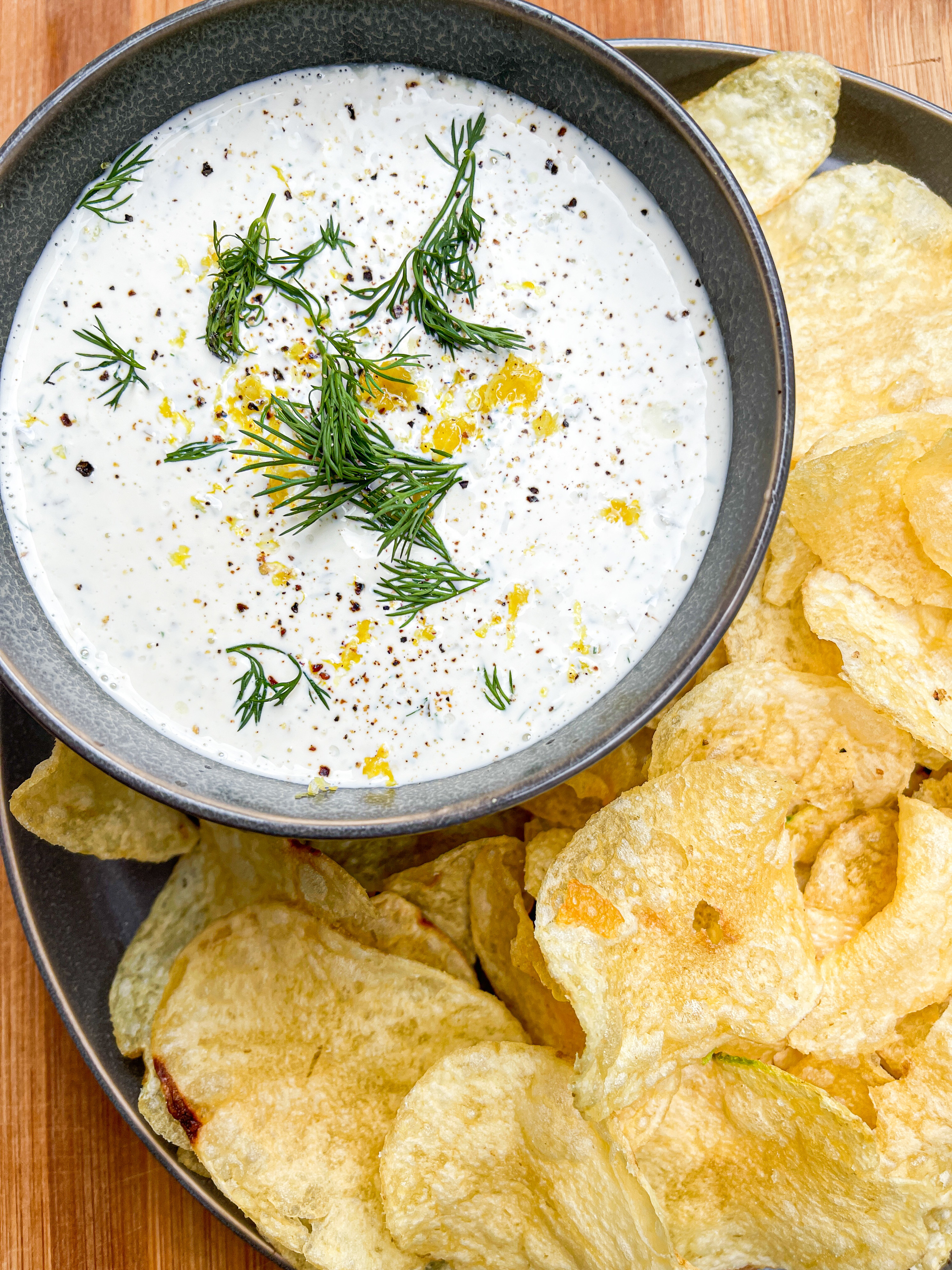 white pickle dip in bowl next to chips