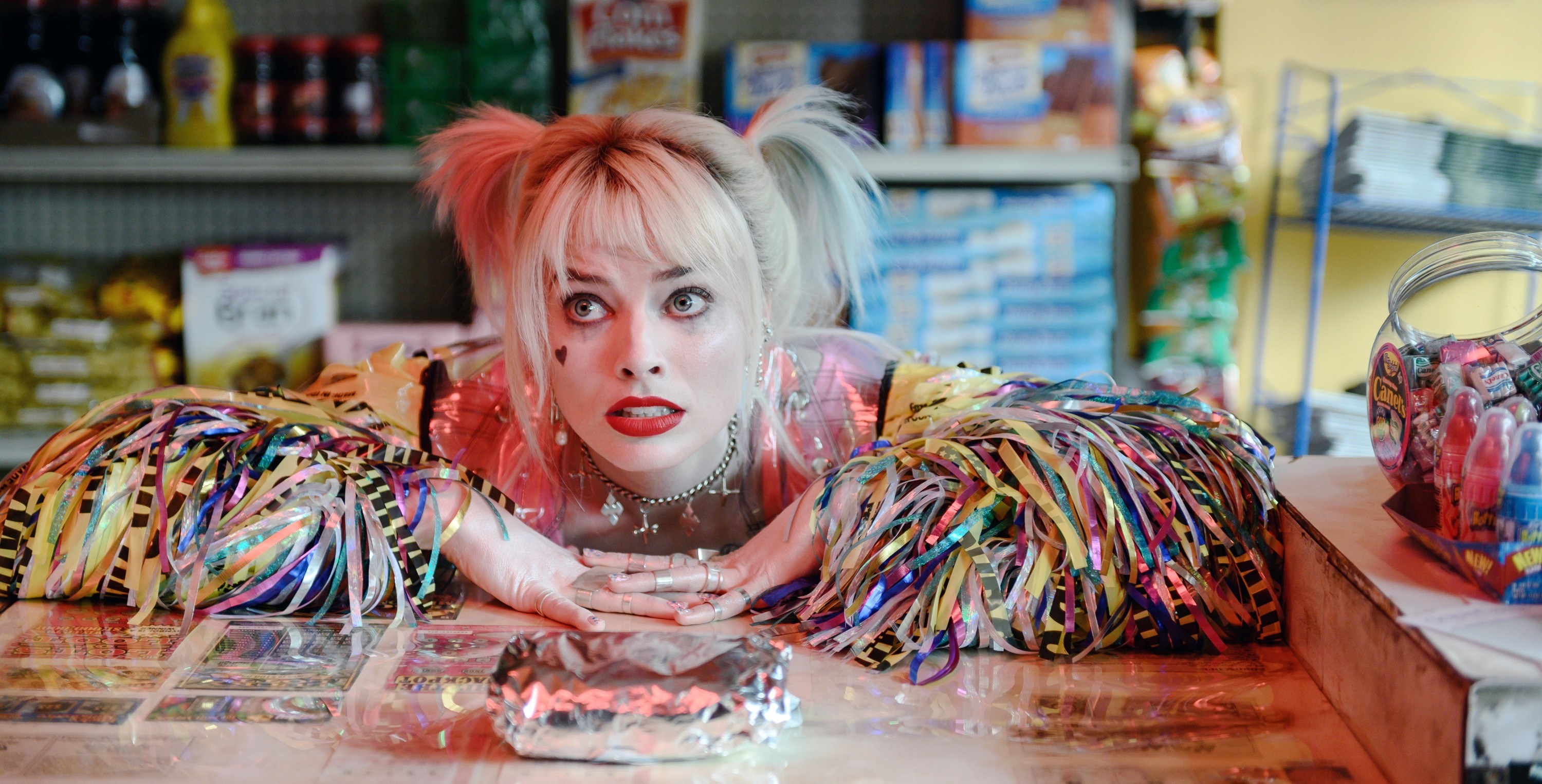 Margot Robbie lays on a convenience store counter