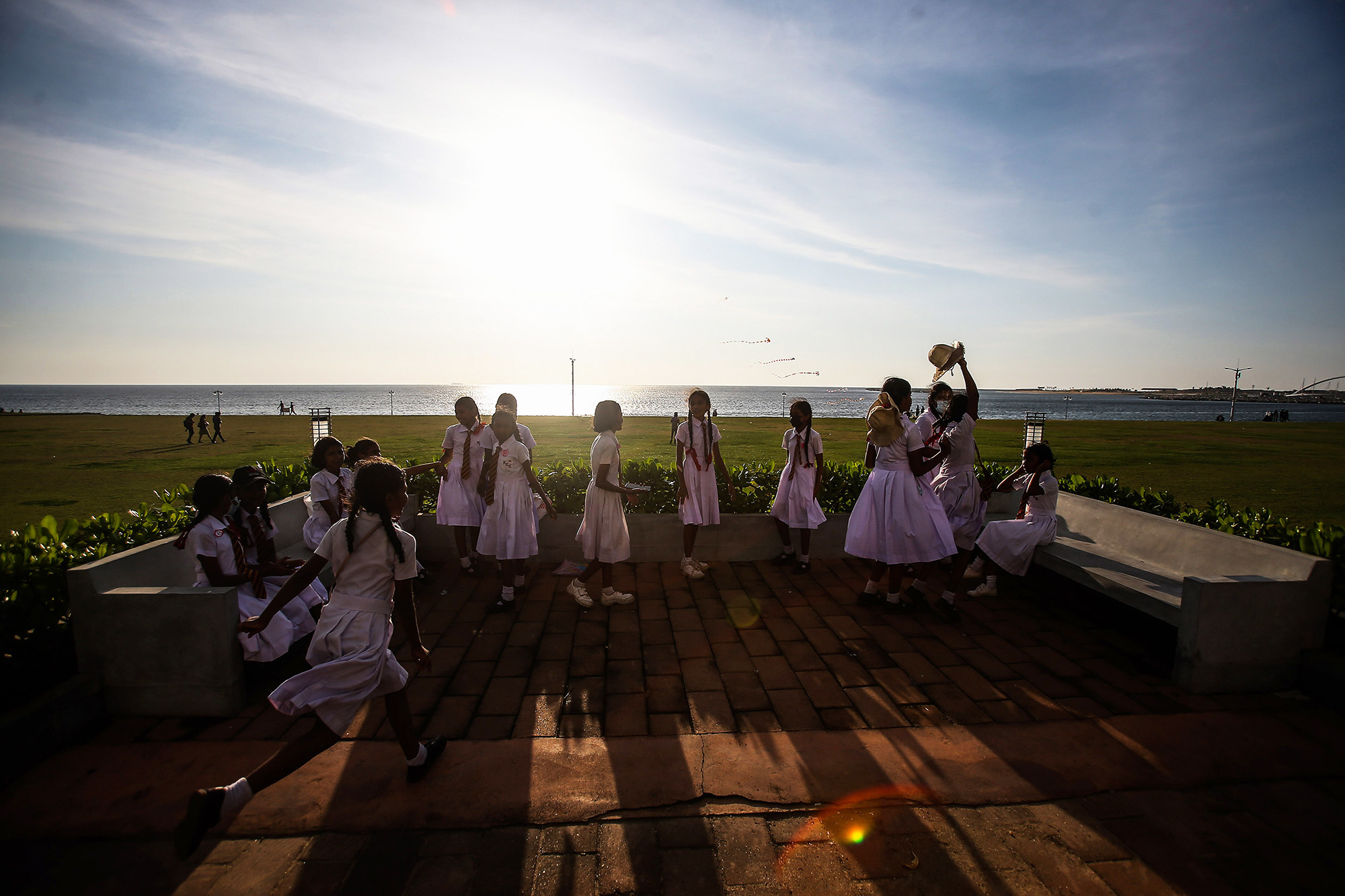 a group of students in white dresses standing outside in the sun
