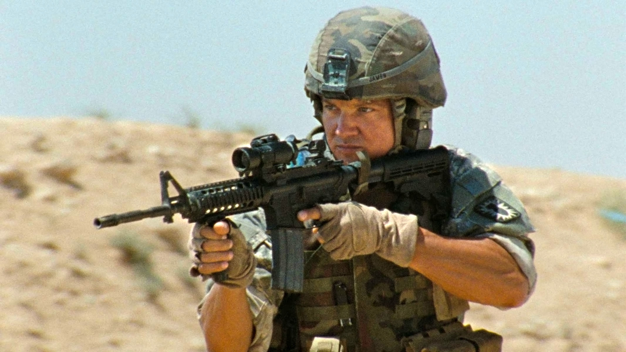 Jeremy Renner as a sergeant holding up a weapon