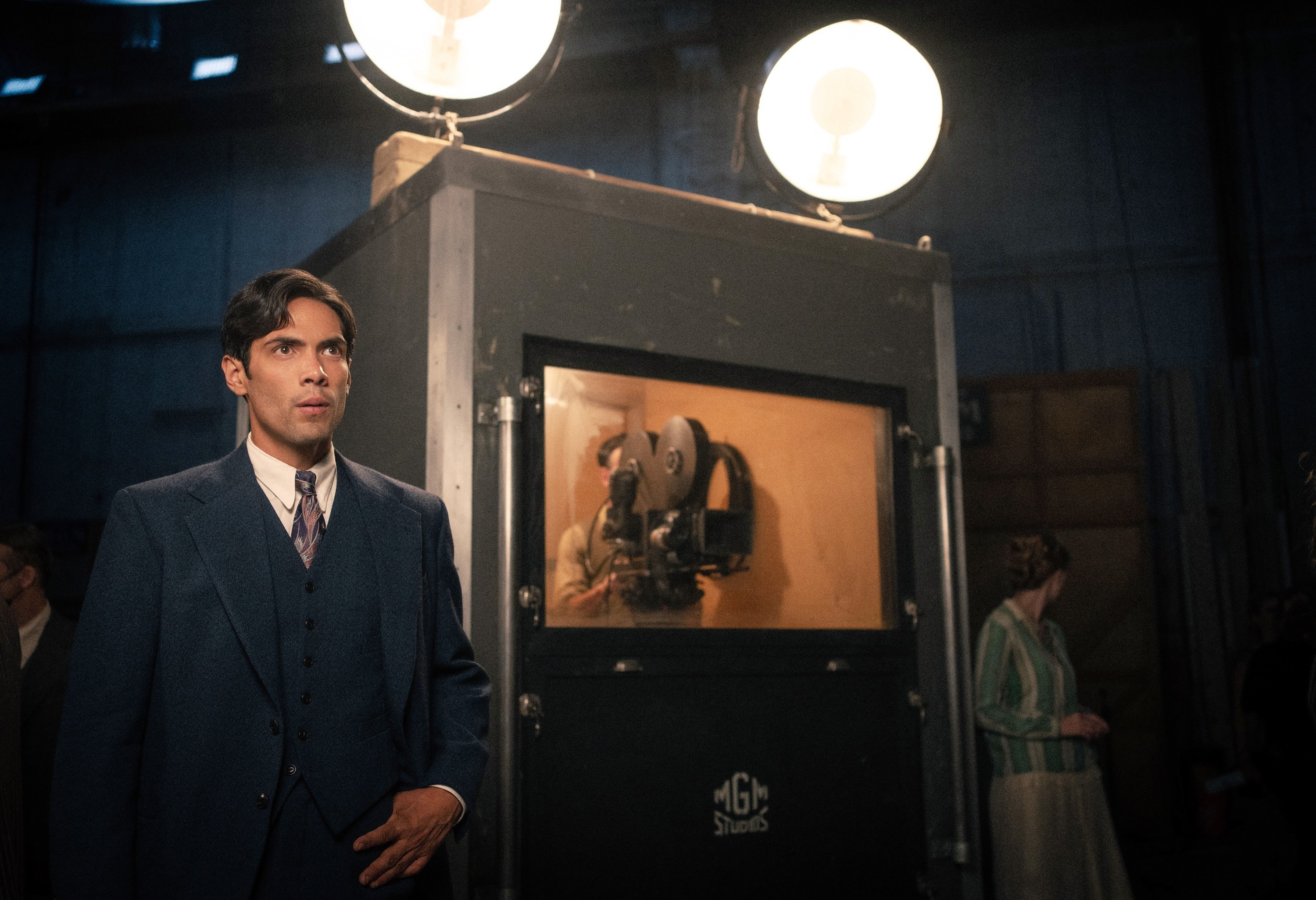 Manny on set, with a camera booth behind him