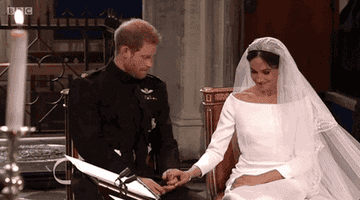 prince harry and meghan markle holding hands whilst sitting on their wedding day