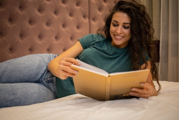 Happy young woman reading at home