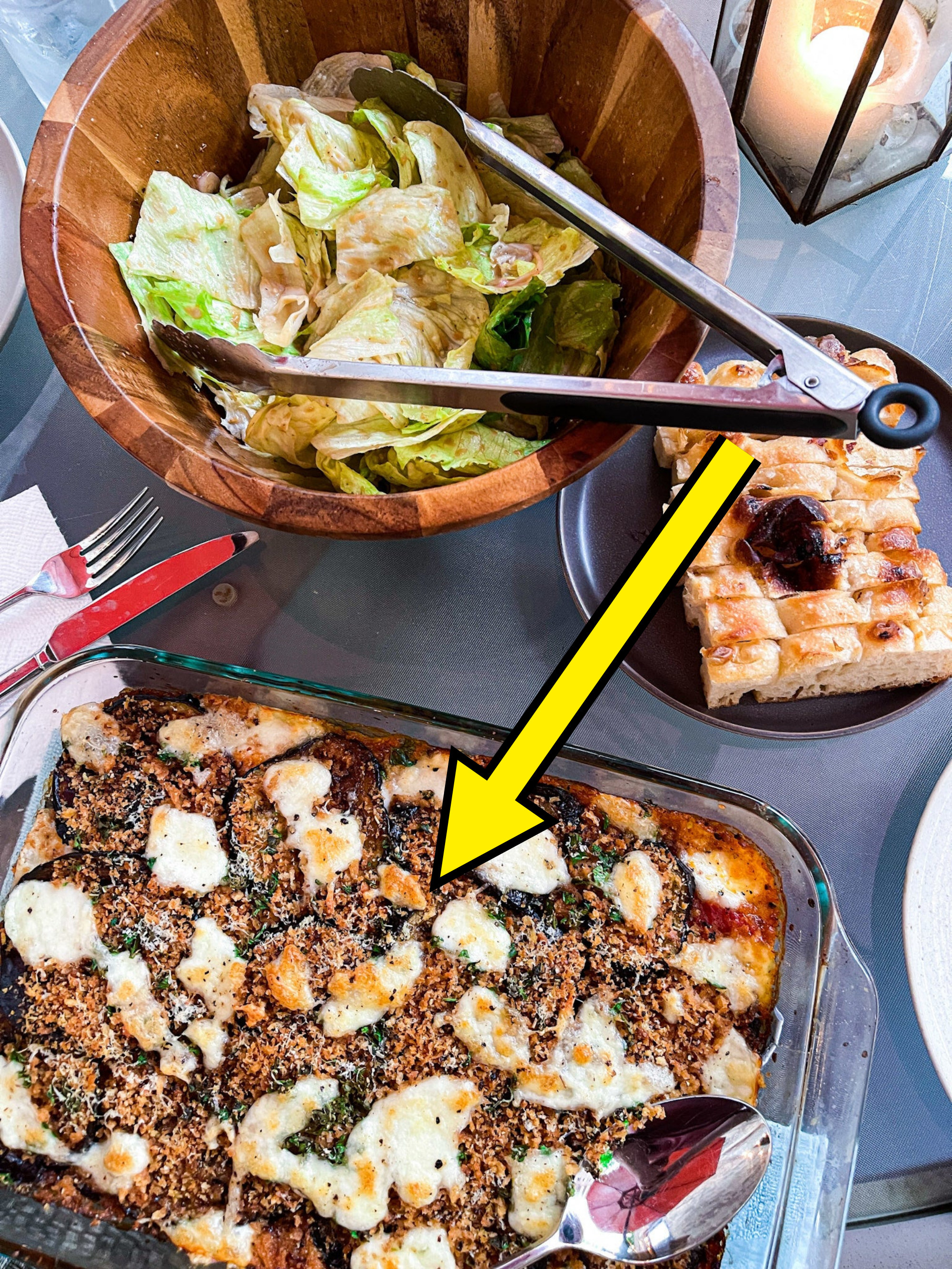 arrow pointing to eggplant parm on a table with other food items