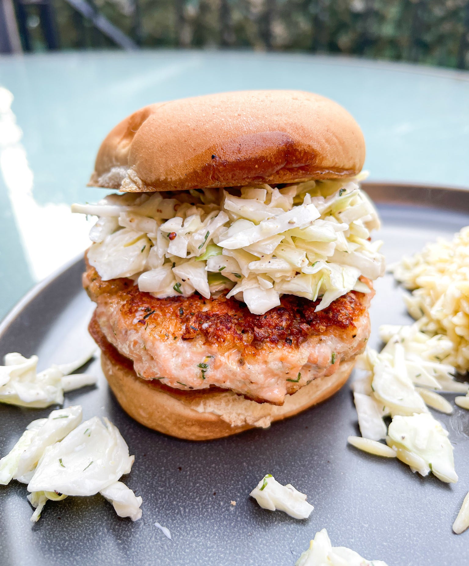 salmon burger with lots of slaw on top