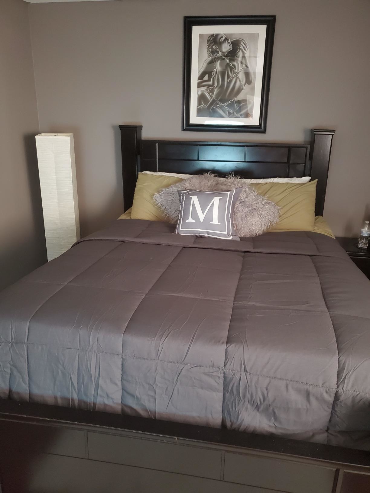 Reviewer&#x27;s photo of the grey comforter on bed
