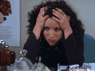 a gif of elaine holding her hair and looking tired and frustrated
