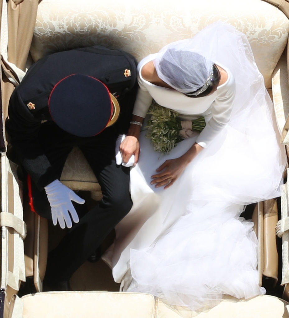 Overhead view of Harry and Meghan holding hands in their carriage on their wedding day