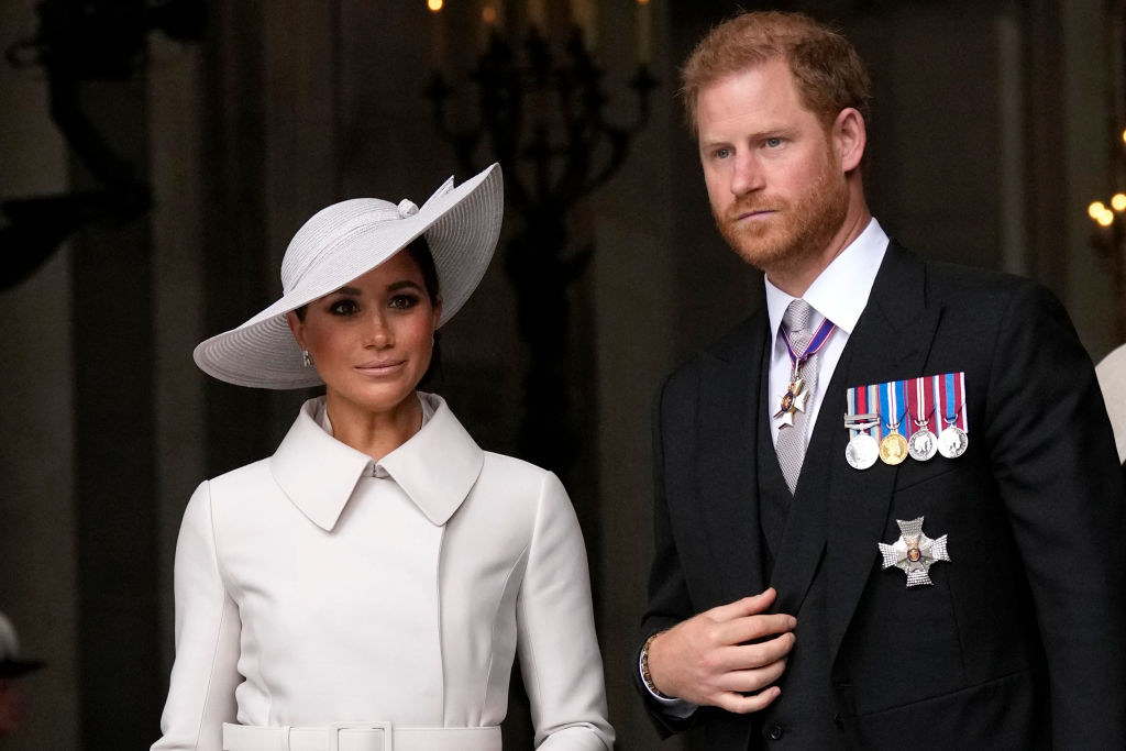 Meghan in a wide-brimmed hat and Harry with medals on his jacket