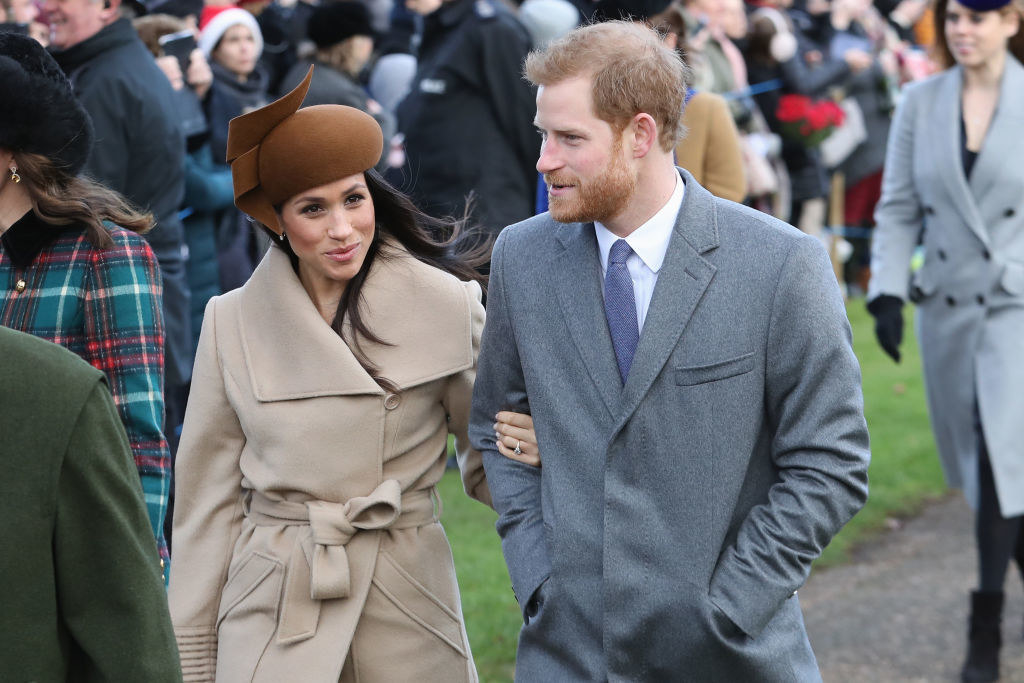 Meghan and Harry arm in arm and wearing coats