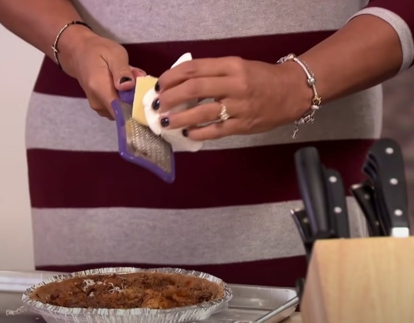 A woman grating cheese using a callous remover