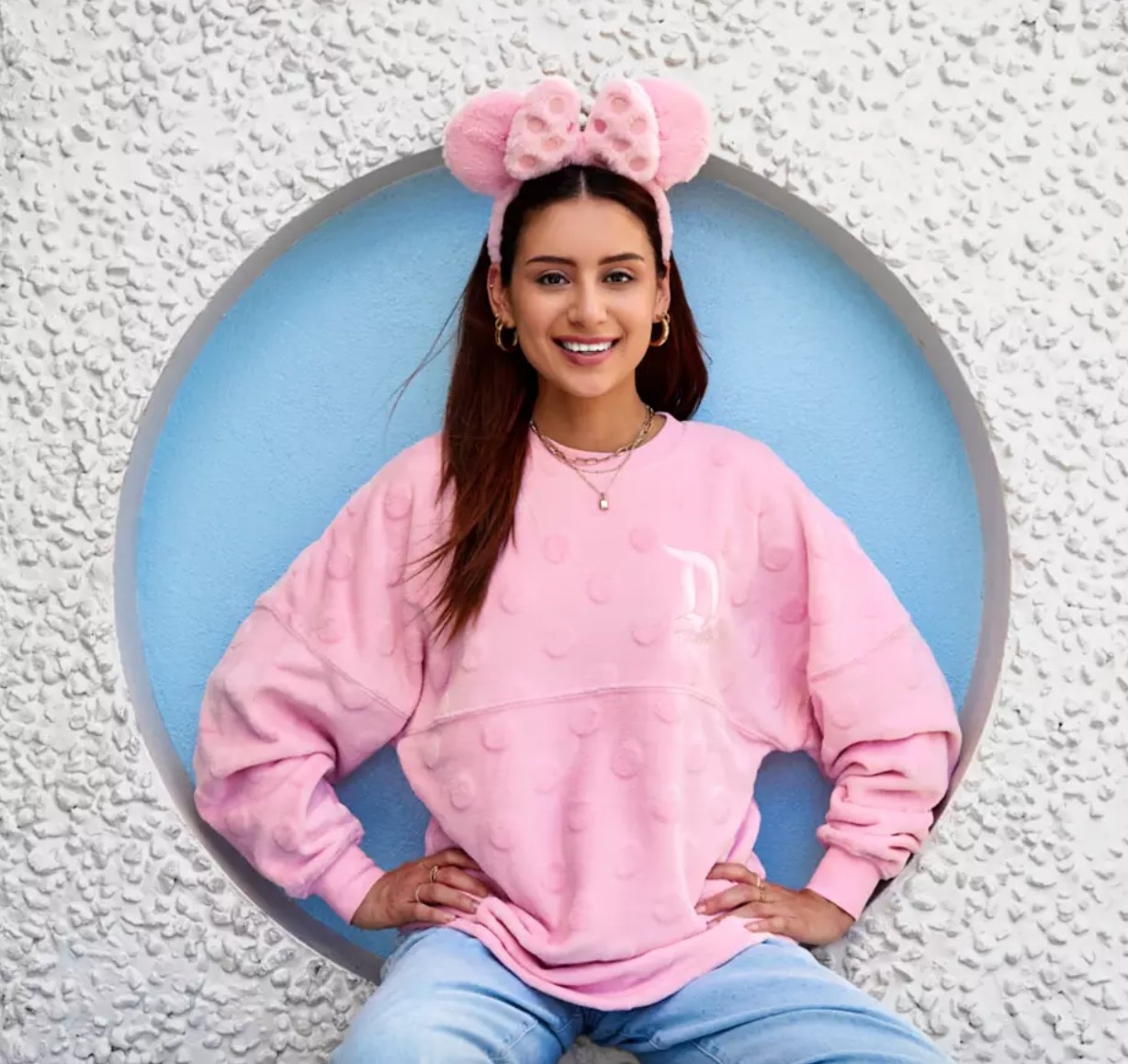 model wearing the fluffy pink ears with a matching sweater