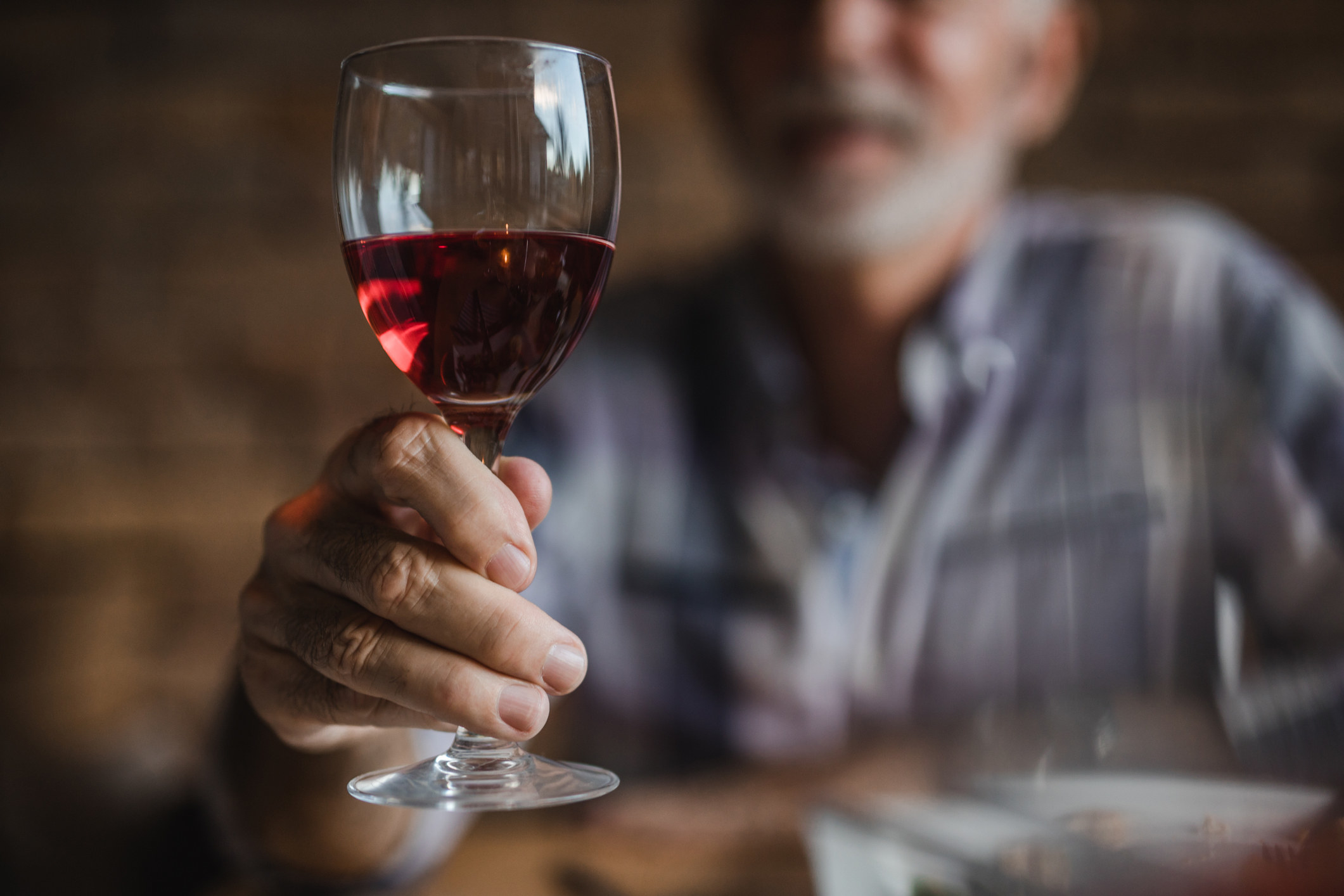 Man holds a glass of wine