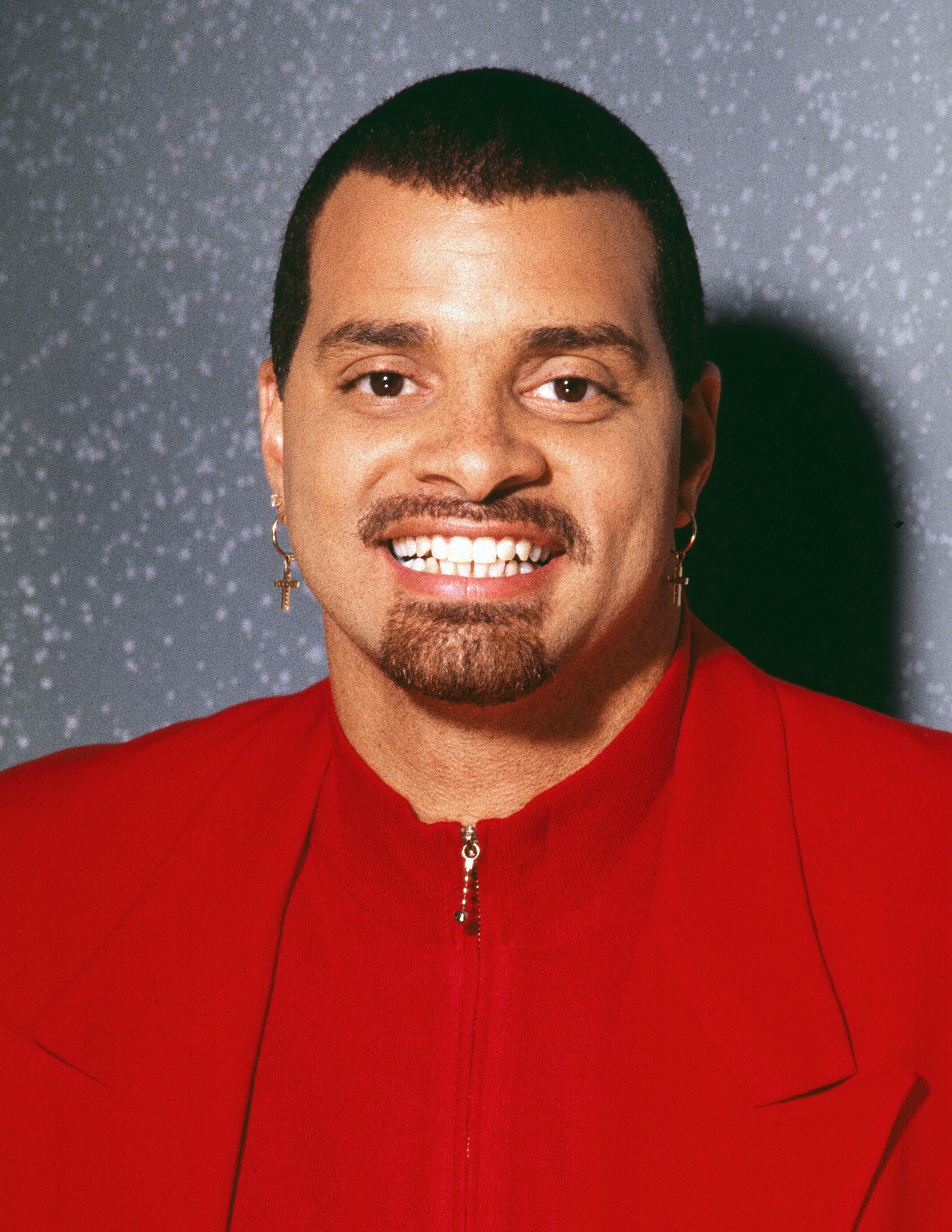 Sinbad posing in a red button down shirt in the 90s
