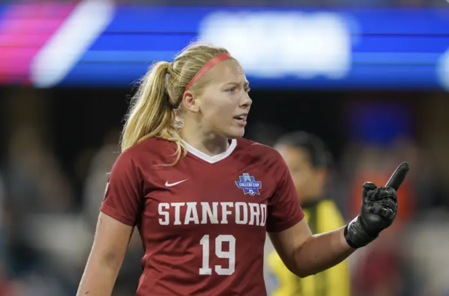 Katie Meyer in a red stanford soccer jersey stands on the field