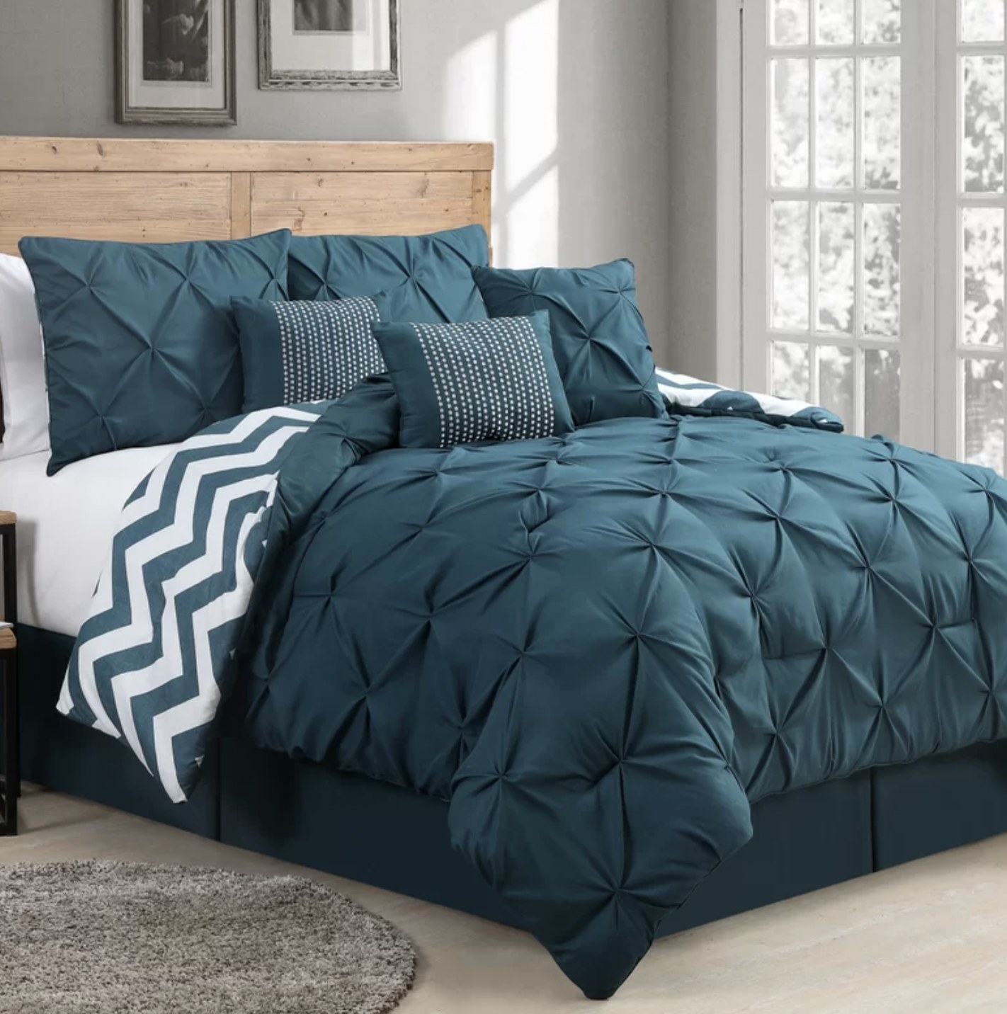 The blue comforter set with throw pillows on bed