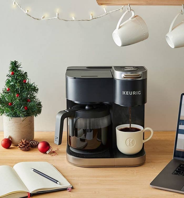 The coffee maker on desk surrounded by gadgets and holiday decor