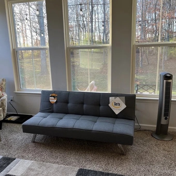 a reviewer photo of the dark gray futon sleeper sofa