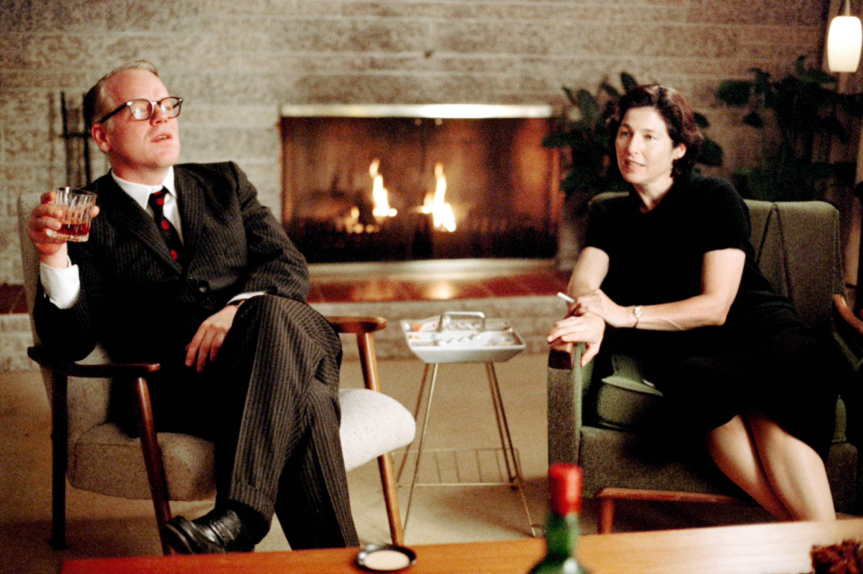 Philip Seymour Hoffmann and Catherine Keener sit in chairs smoking