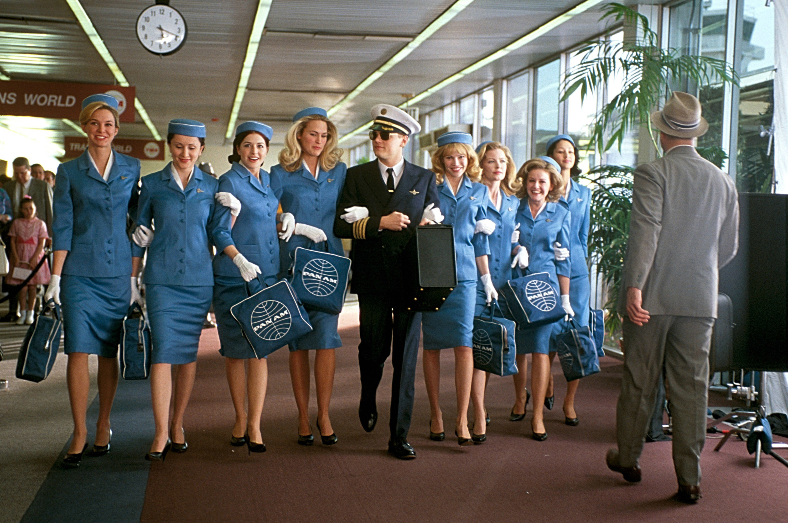 Leonardo Di Caprio walks with a bunch of flight attendants