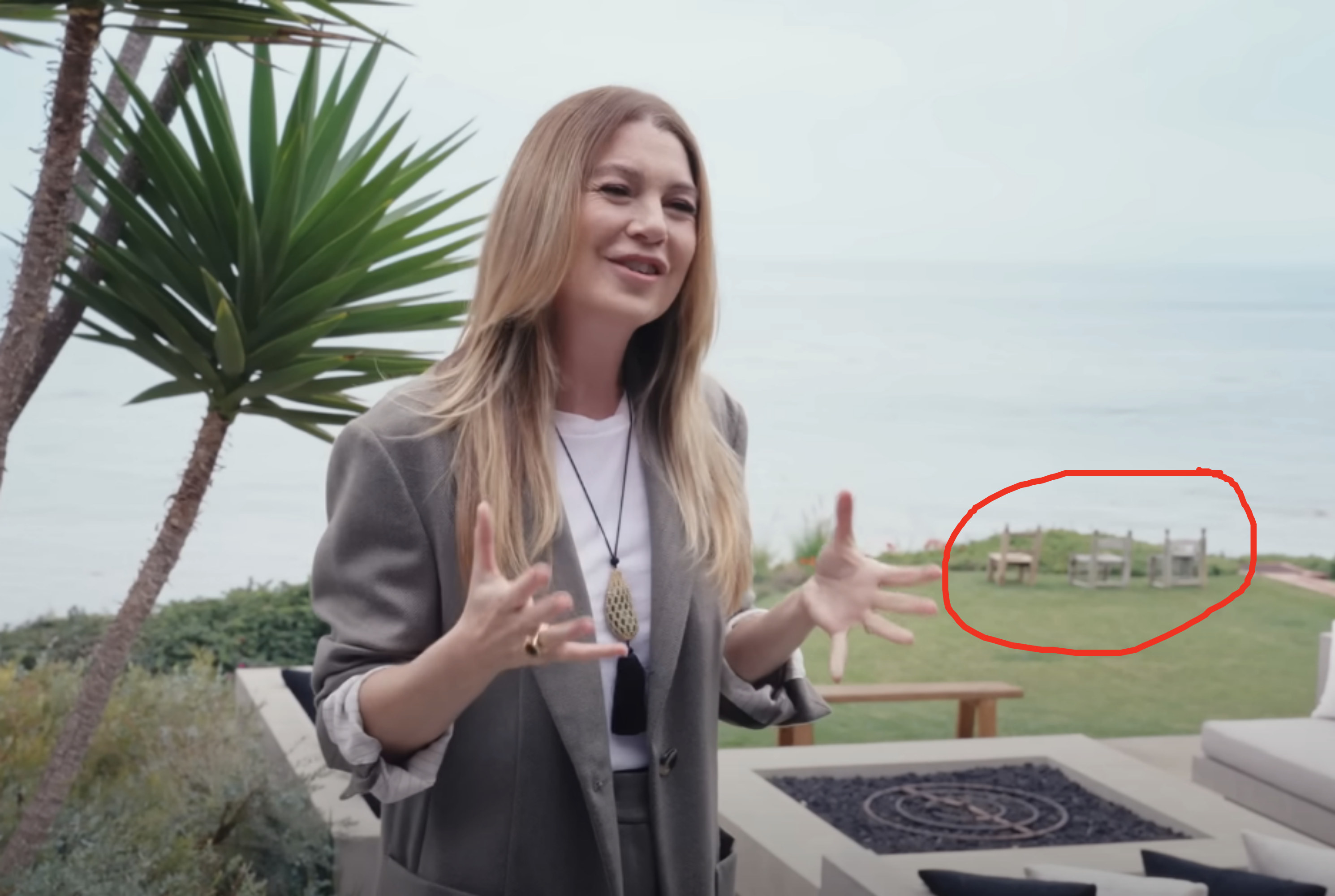 three chairs in the background of the house overlooking the ocean