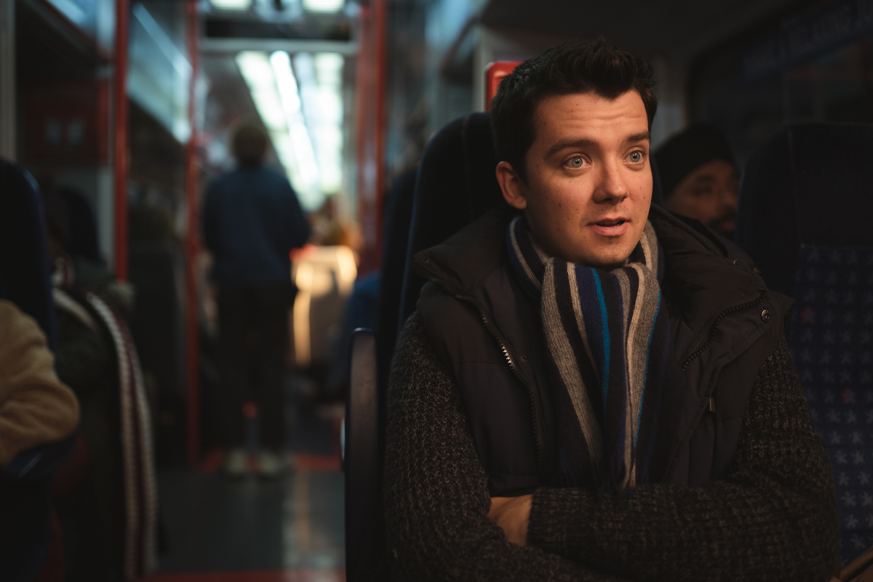 Asa Butterfield sits on a train