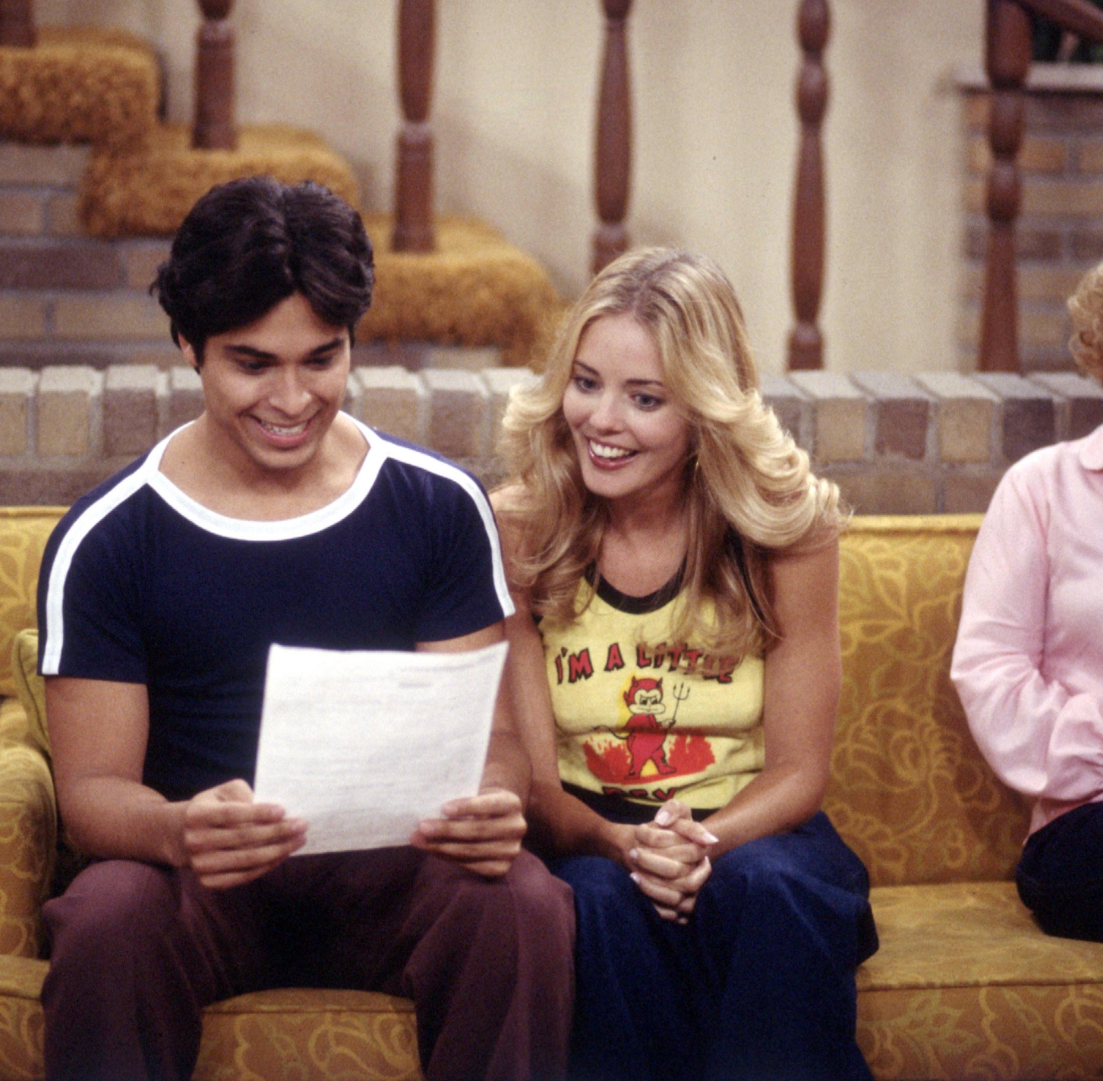 Laurie and Fez looking at a piece of paper and smiling