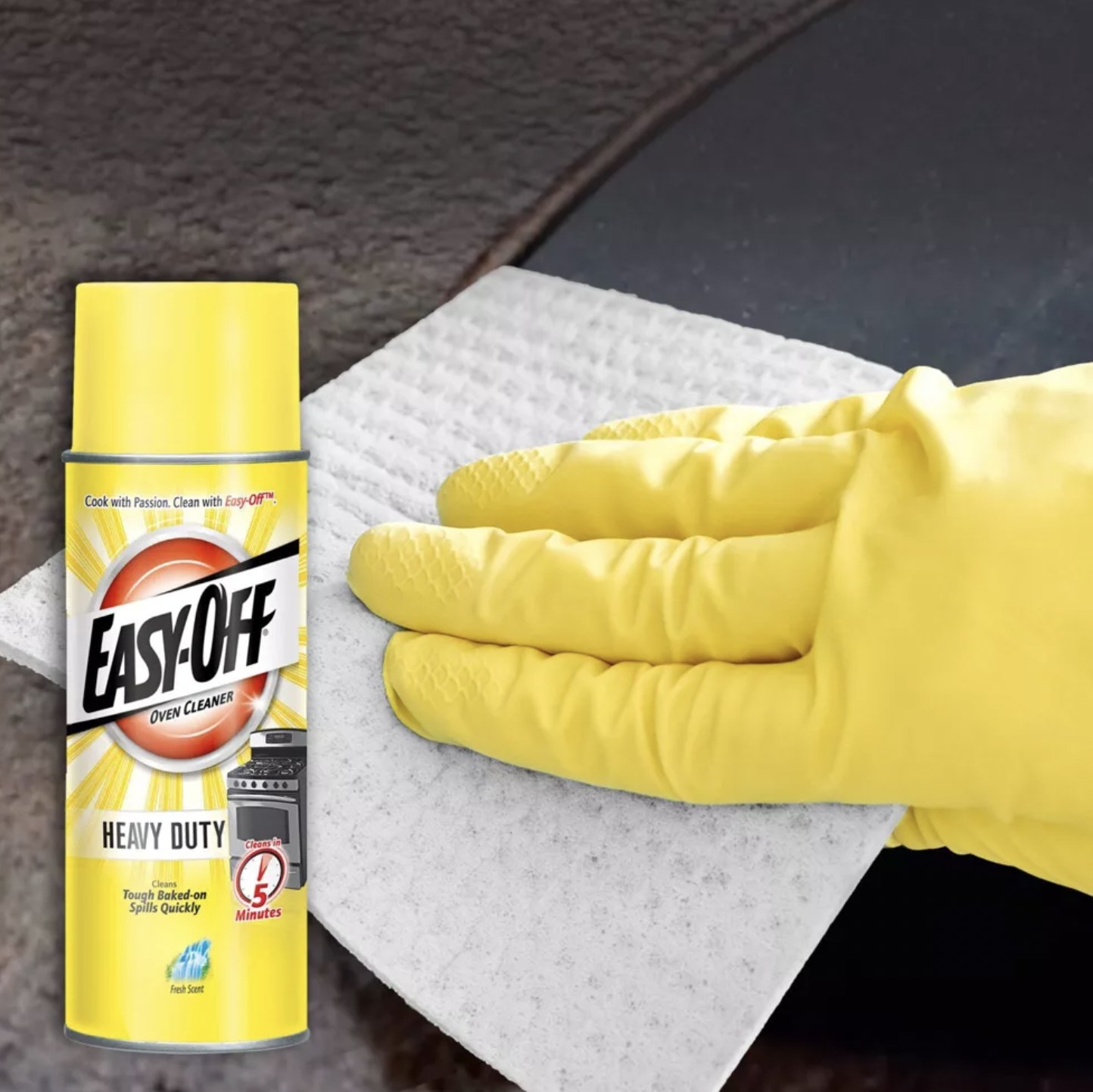 Someone wearing glove and wiping cloth along surface with bottle of Easy-off heavy duty cleaner shown