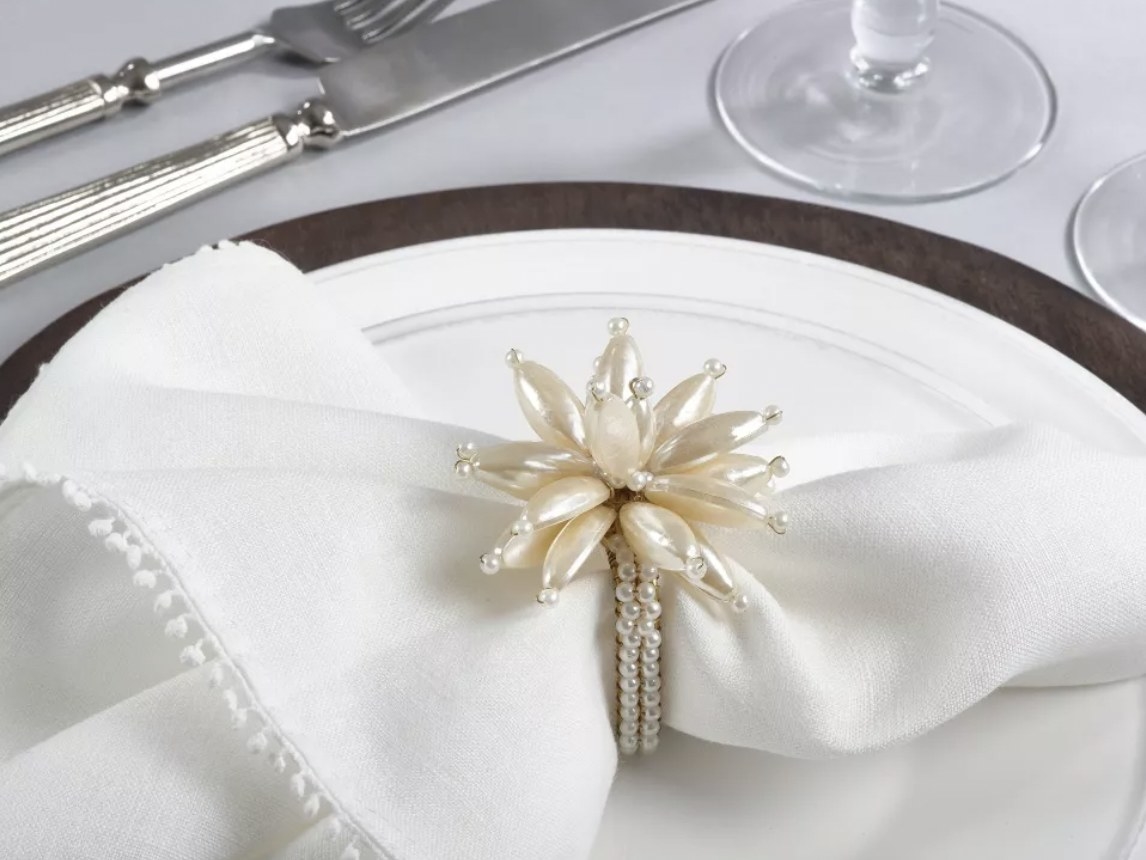 The napkin ring over white napkin on place setting