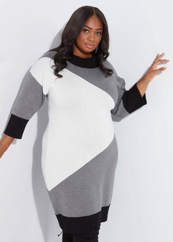 model in knee-length white, grey, and black long sleeve colorblock sweater dress