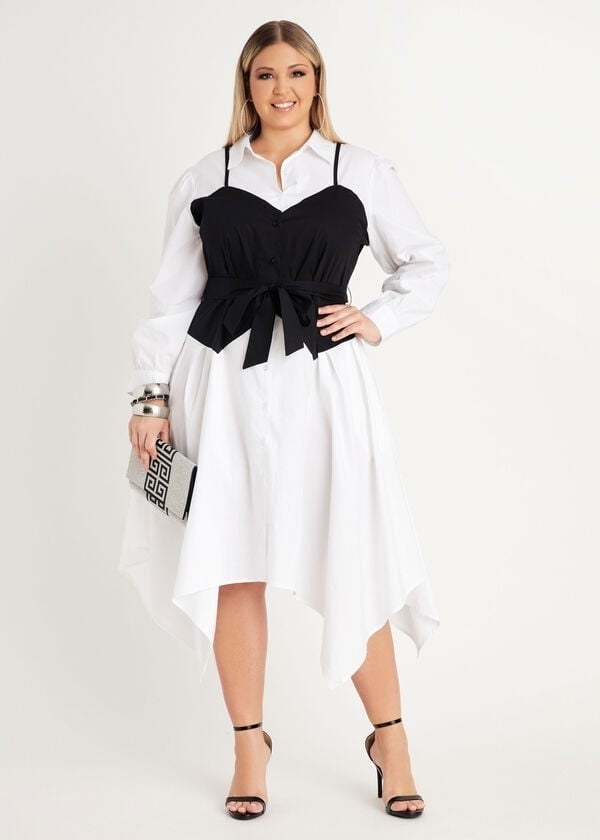 model in a white long sleeve collared shirt midi dress with a scarf hem and a black tank bustier with a bow over it