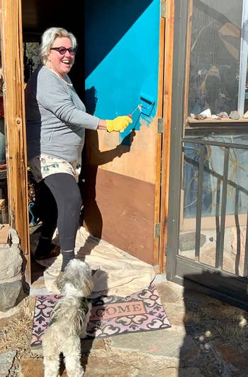 A reviewer painting their front door turquoise