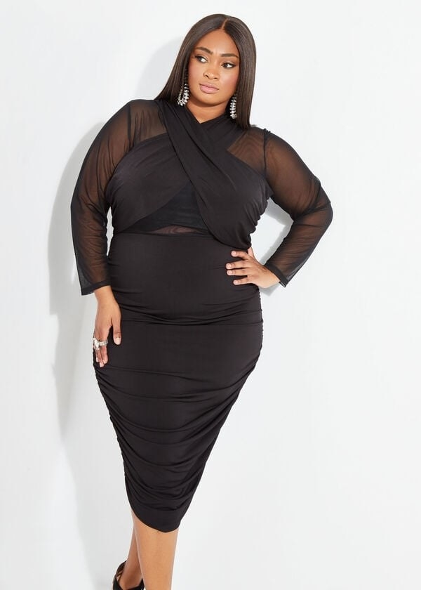 model in black tight midi dress with mesh sleeves and cutouts