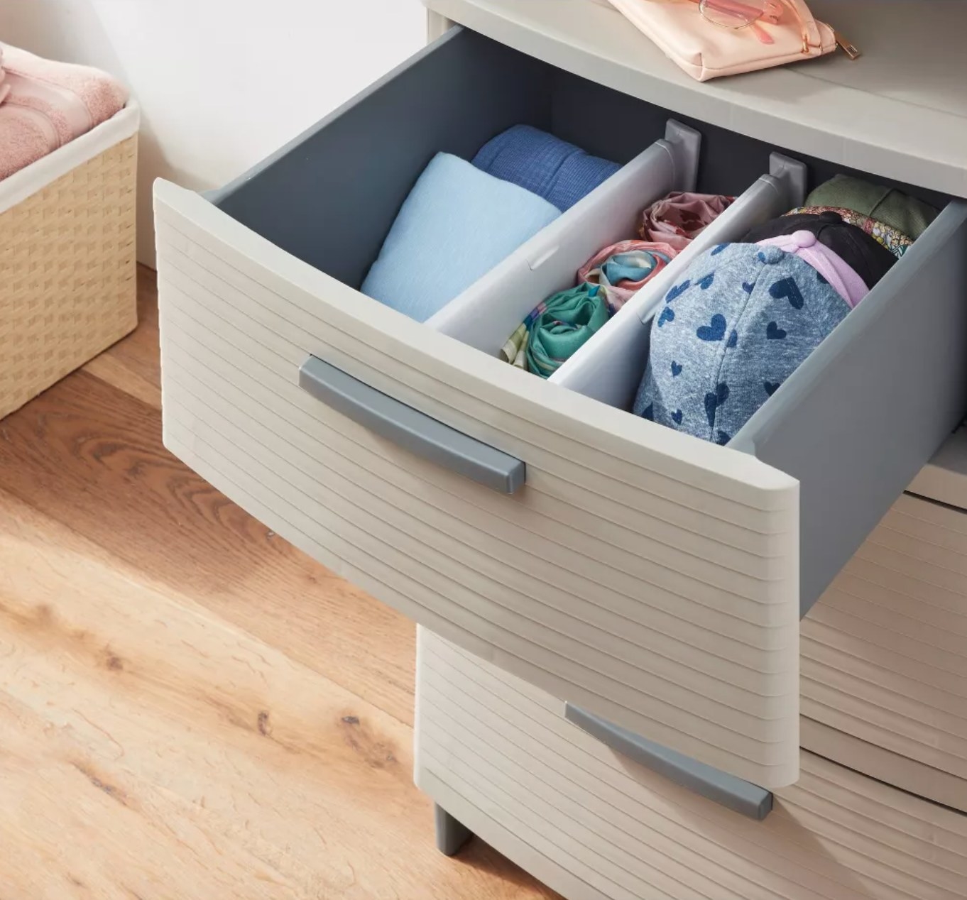 the white plastic dividers in a grey dresser, separating clothes and hats