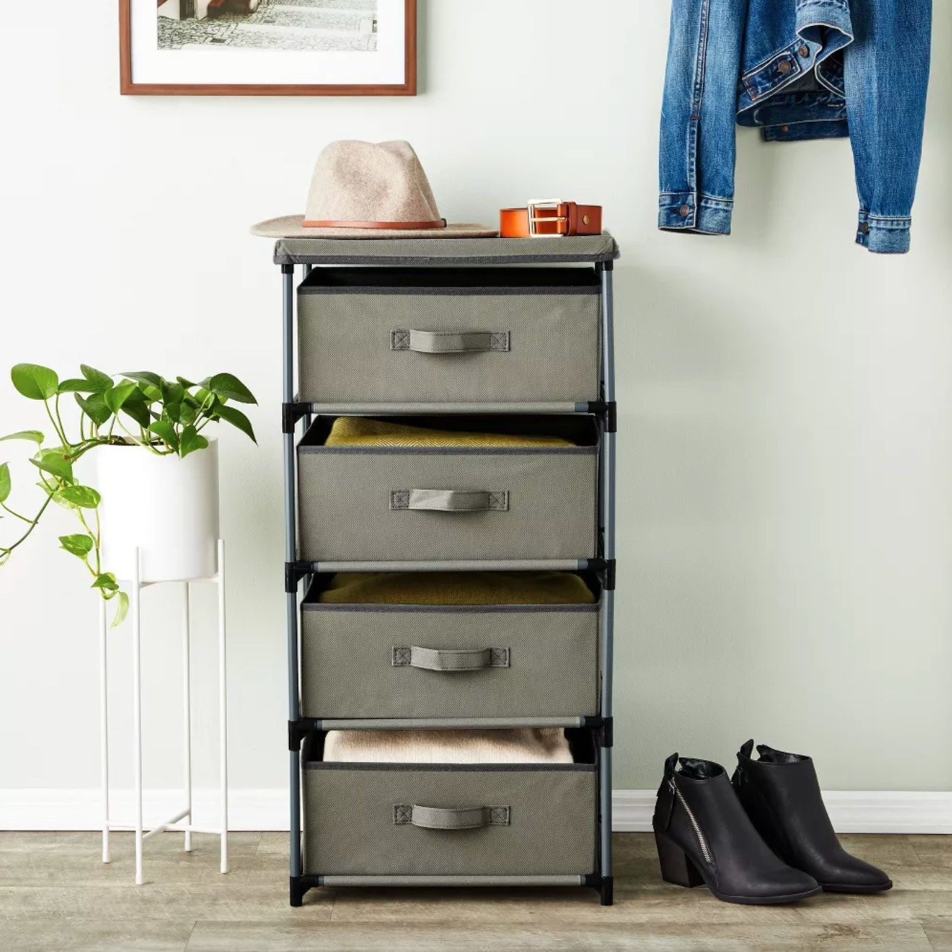 the black and green stack of drawers with various clothes and accessories