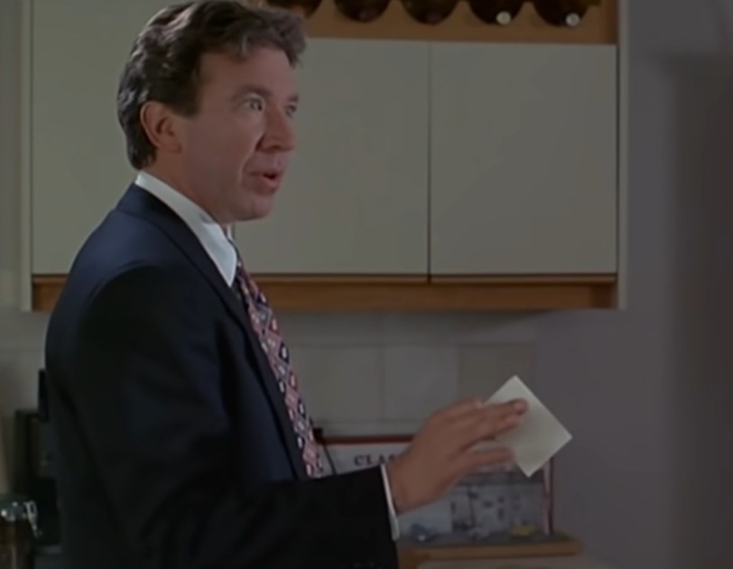 Tim Allen as Scott holding a paper with a phone number on it