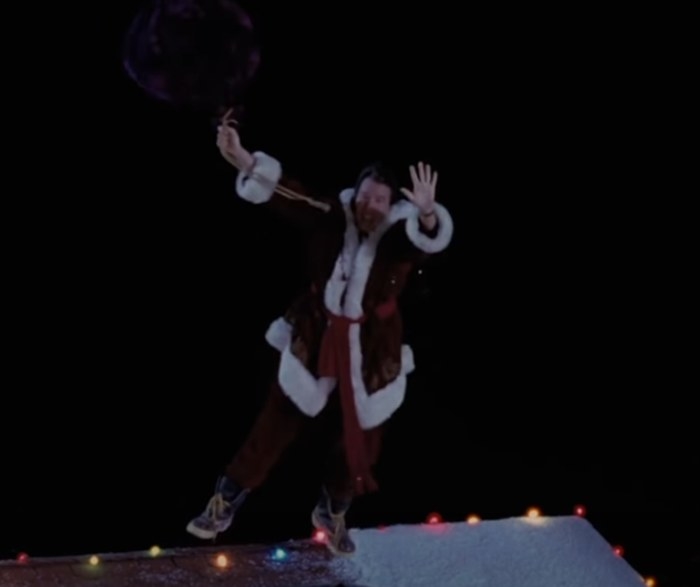 Tim Allen as Scott floating to the sky holding on to Santas gift bag