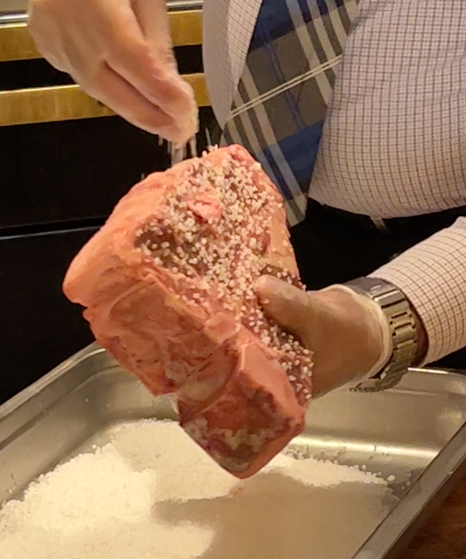 A raw steak with a whole layer of sea salt