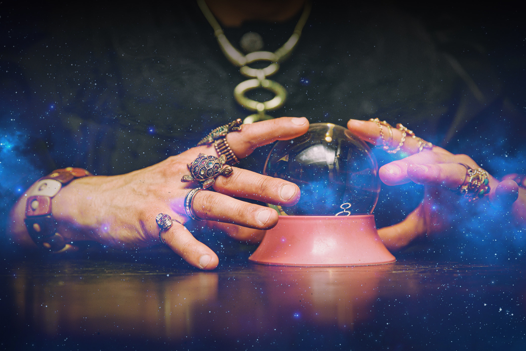 A psychic holding a crystal ball with stars edited around it