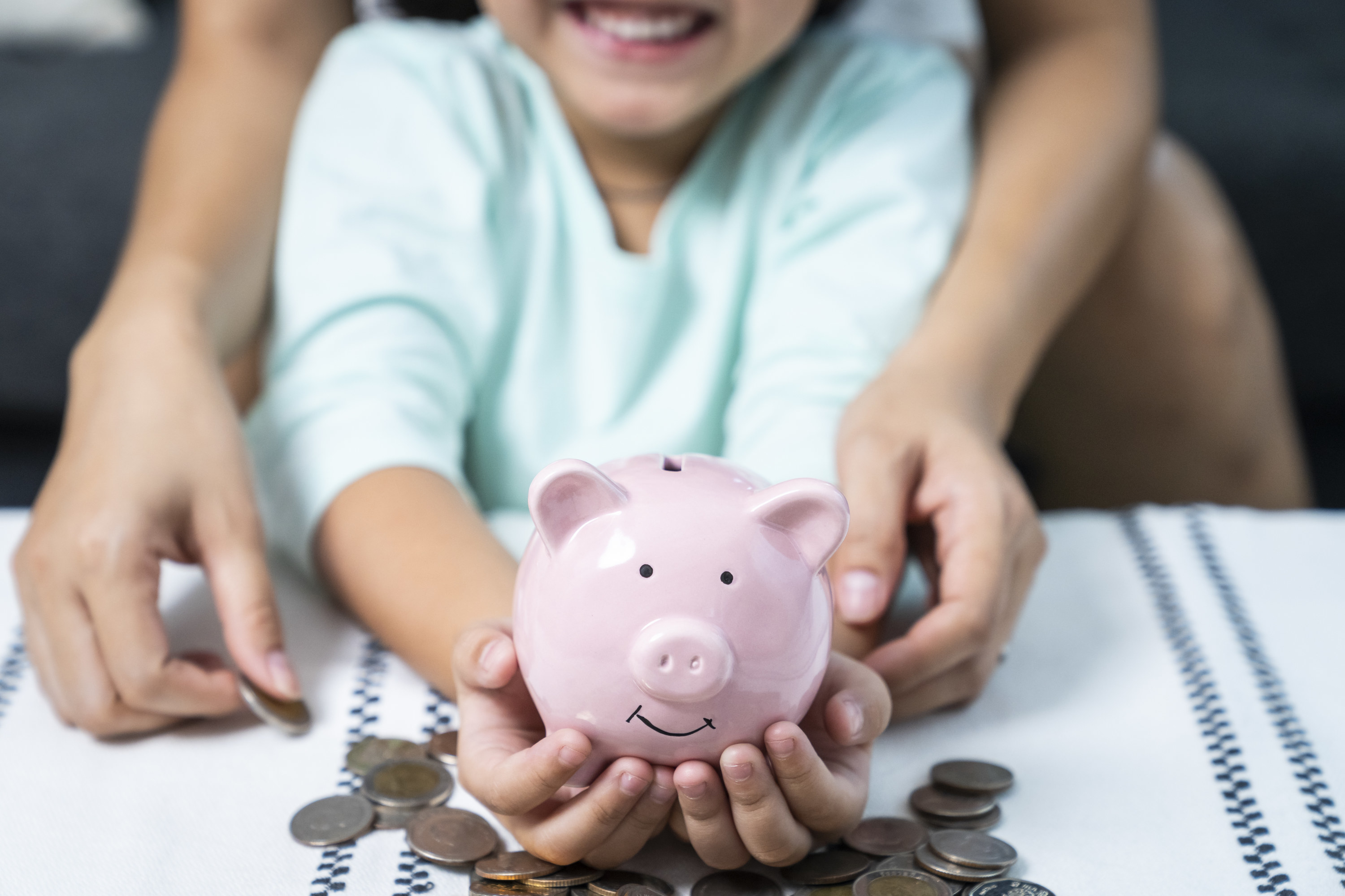Mother and child holding a piggy bank