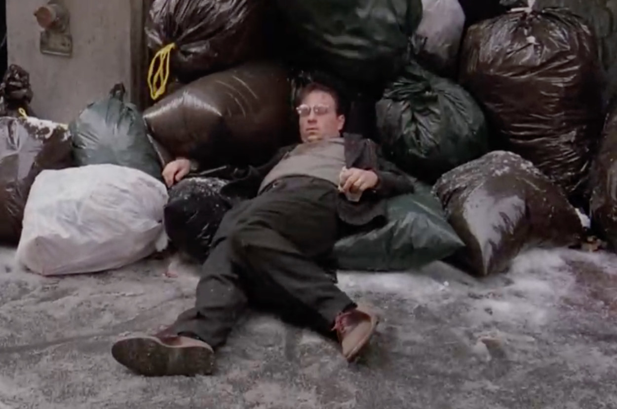 eliot lying in bags of trash